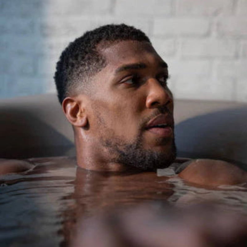 Man in a Monk bathtub with a neutral background