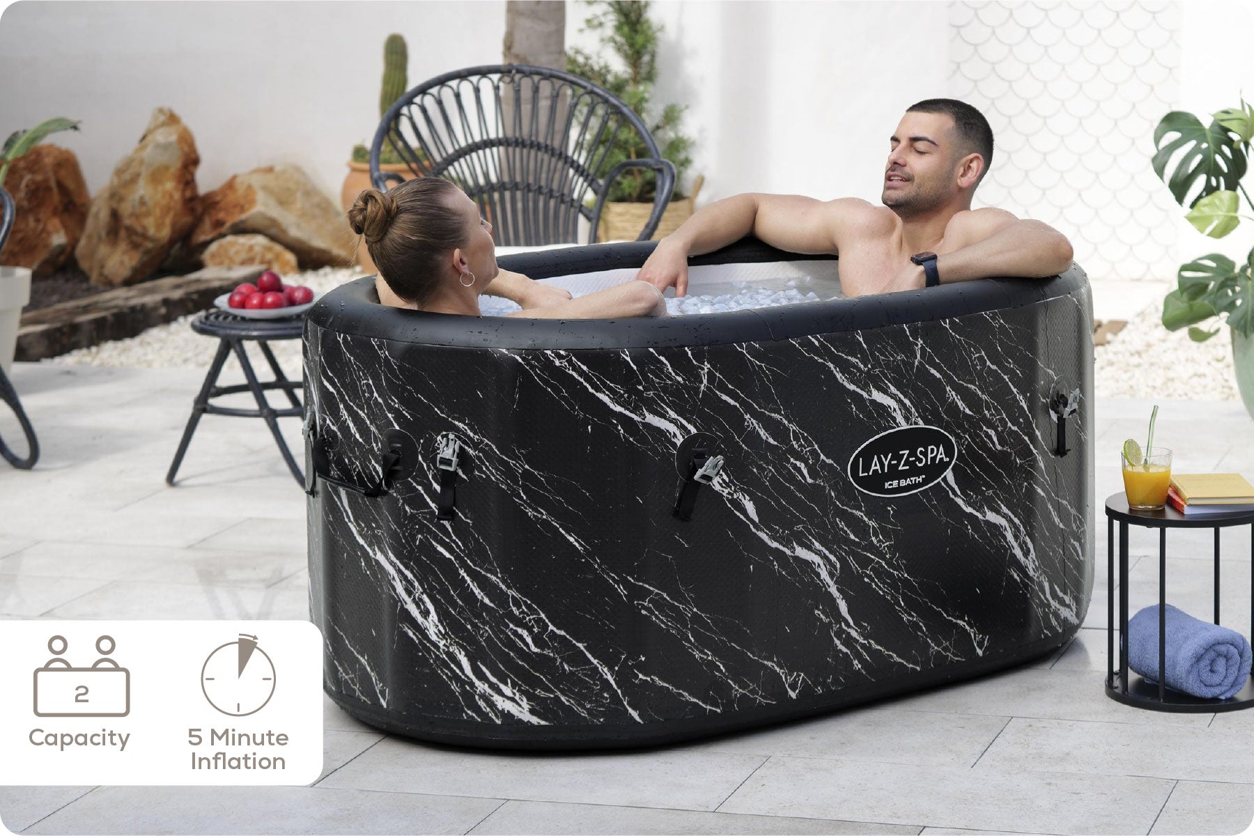 Inflatable hot tub with marble design being used by a couple in an outdoor setting.