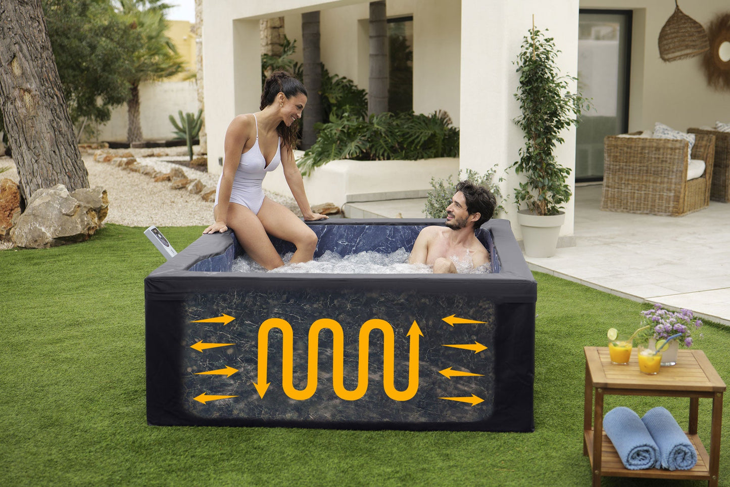 Two people in a portable hot tub with a patio and garden in the background