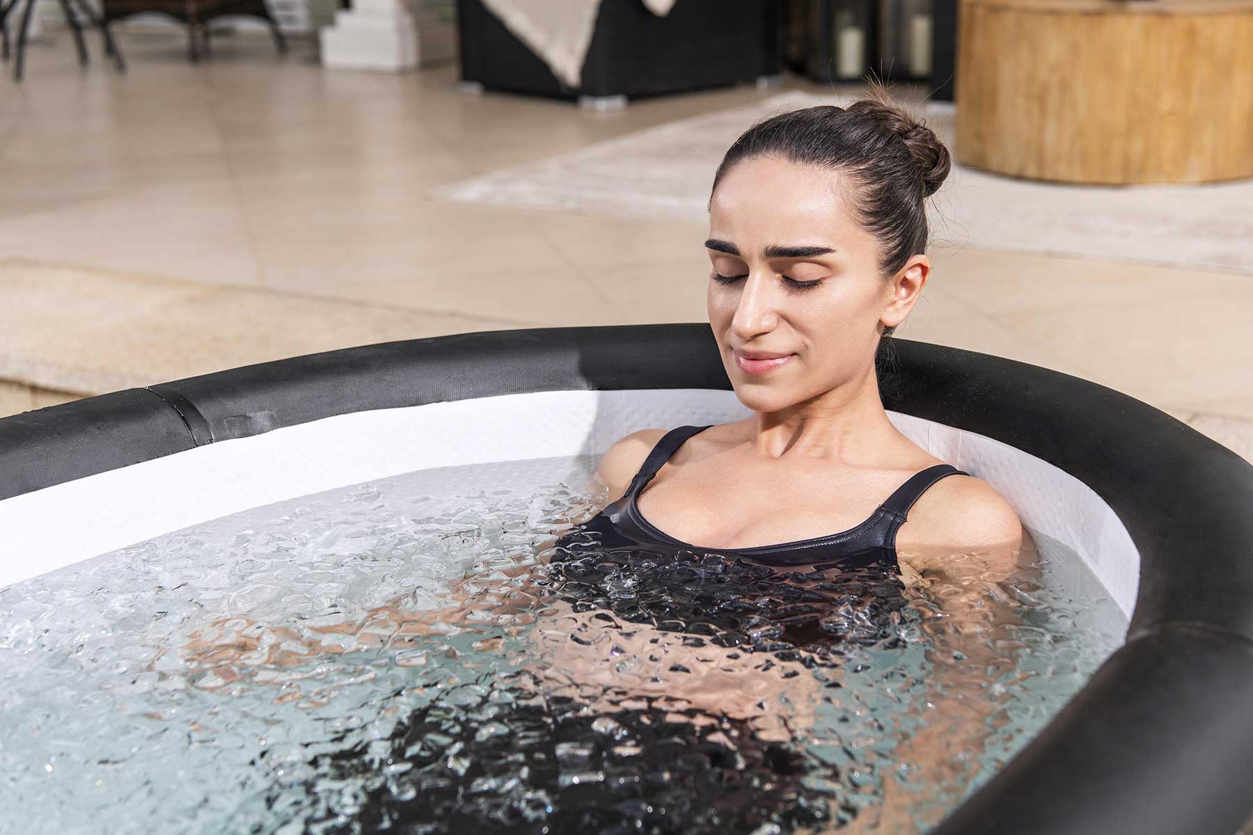 Woman in a lay z spa hot tub with a blurred indoor background