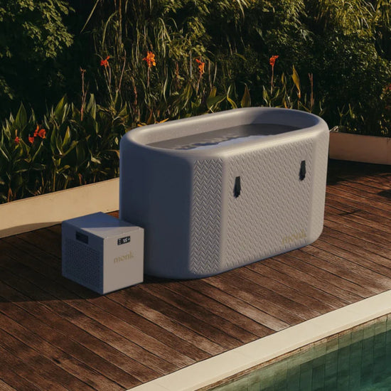 Monk Shiver + Nomad Bundle on a wooden deck next to a pool with greenery in the background