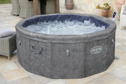 Gray Lay-Z-Spa hot tub on a patio with outdoor furniture and plants.