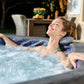 Woman relaxing in a hot tub with bubbles, outdoor setting