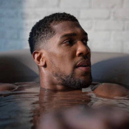 Man in a Monk bathtub with a neutral background 