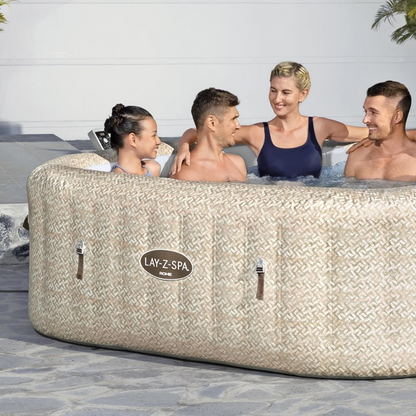 People enjoying a hot tub branded 'Lay-Z-Spa' outdoors.