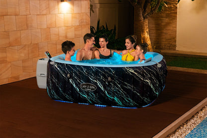 Family of five enjoying a hot tub in a warm indoor setting