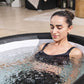 Woman in a lay z spa hot tub with a blurred indoor background