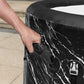 Person opening a black marble-patterned trash can with a white interior.