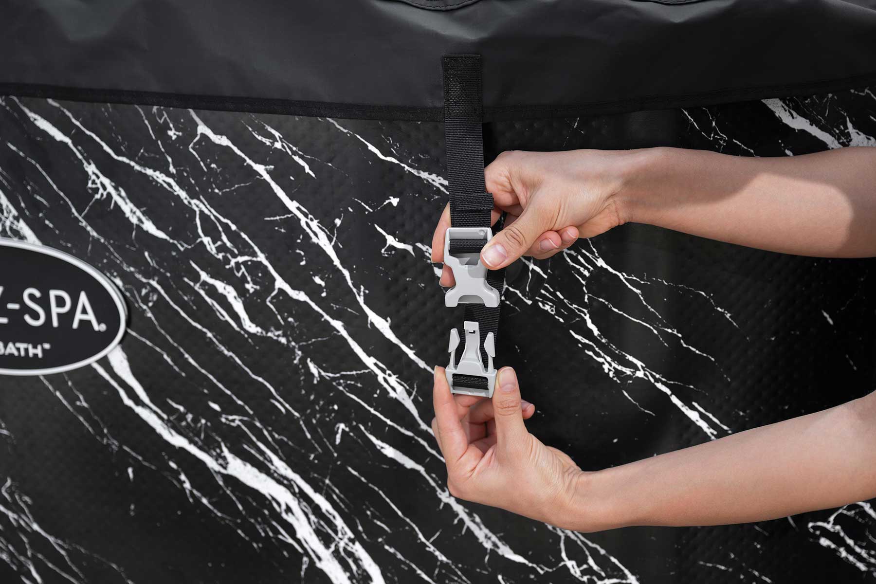 Person securing a strap on a black and white marble-patterned cover with 'E-SPA' branding.