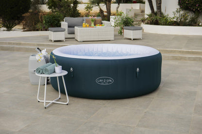 Inflatable hot tub with 'Lay-Z-Spa' branding on a patio area with outdoor furniture.